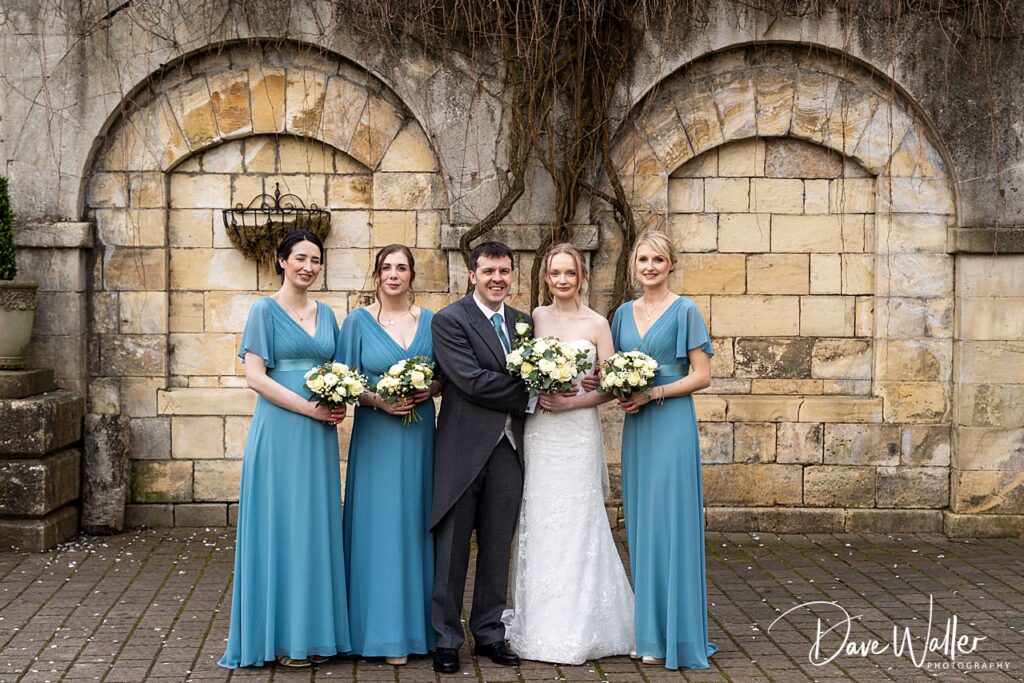 Wedding couple with bridesmaids in blue dresses.