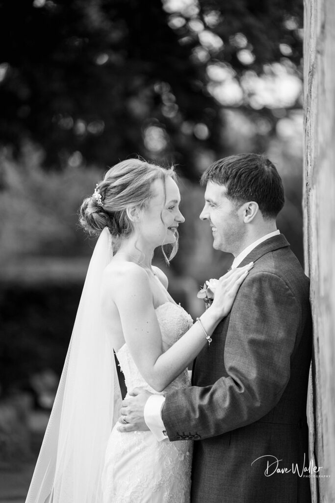 Bride and groom smiling outdoors on wedding day.