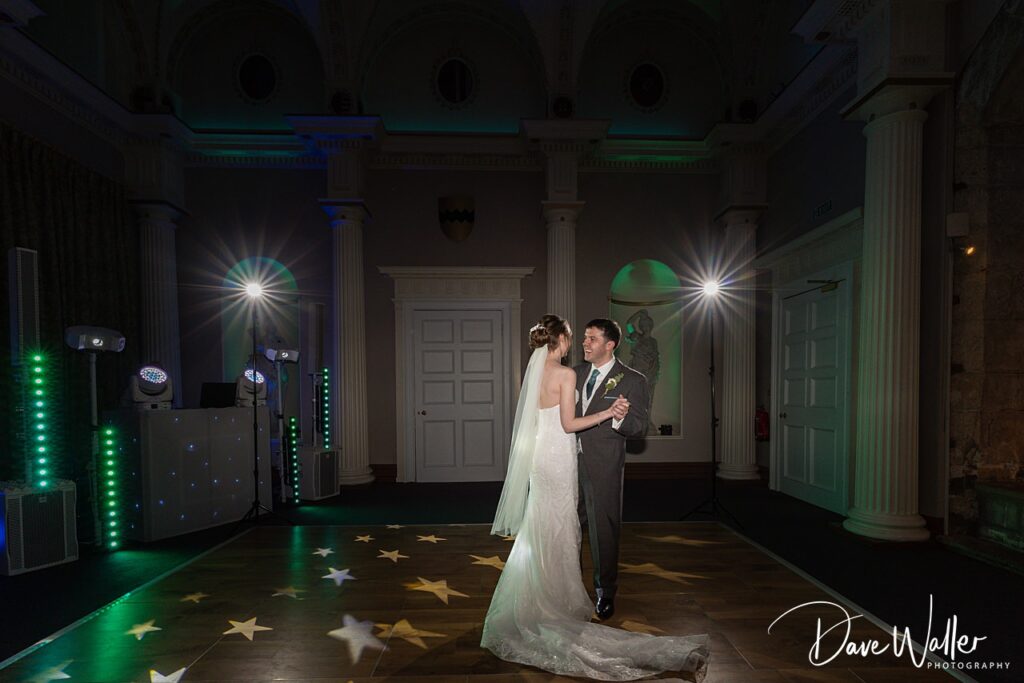Bride and groom dancing under star lights at wedding.