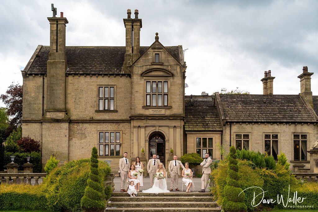 Wedding party outside historic stone building.