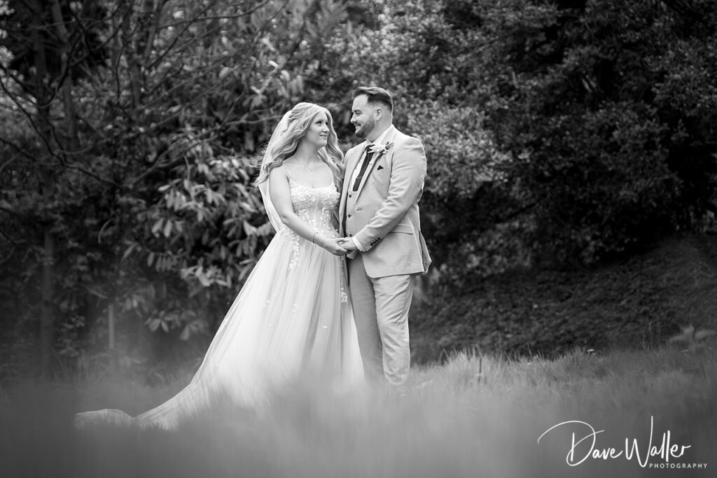 Bride and groom holding hands in garden