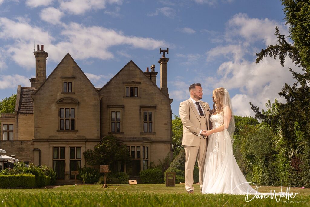 Bride and groom outside manor house.