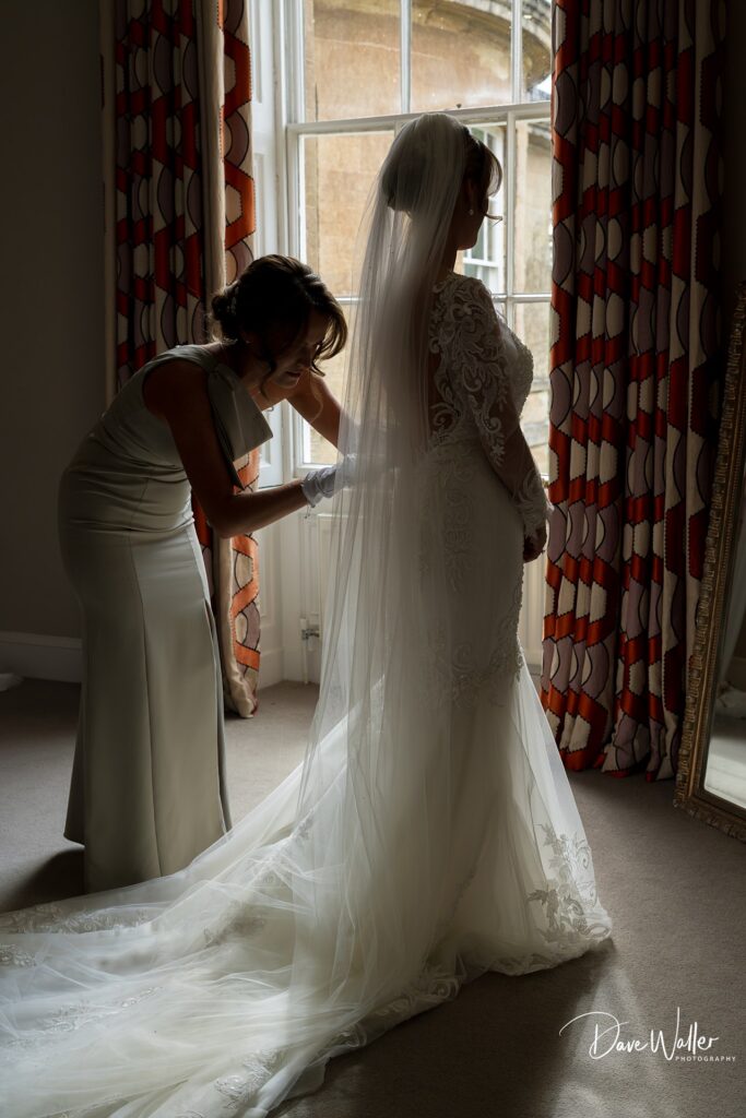 Bride getting ready, dressed in elegant gown.
