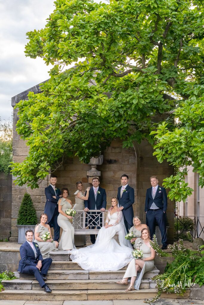 Wedding party posing in garden under tree