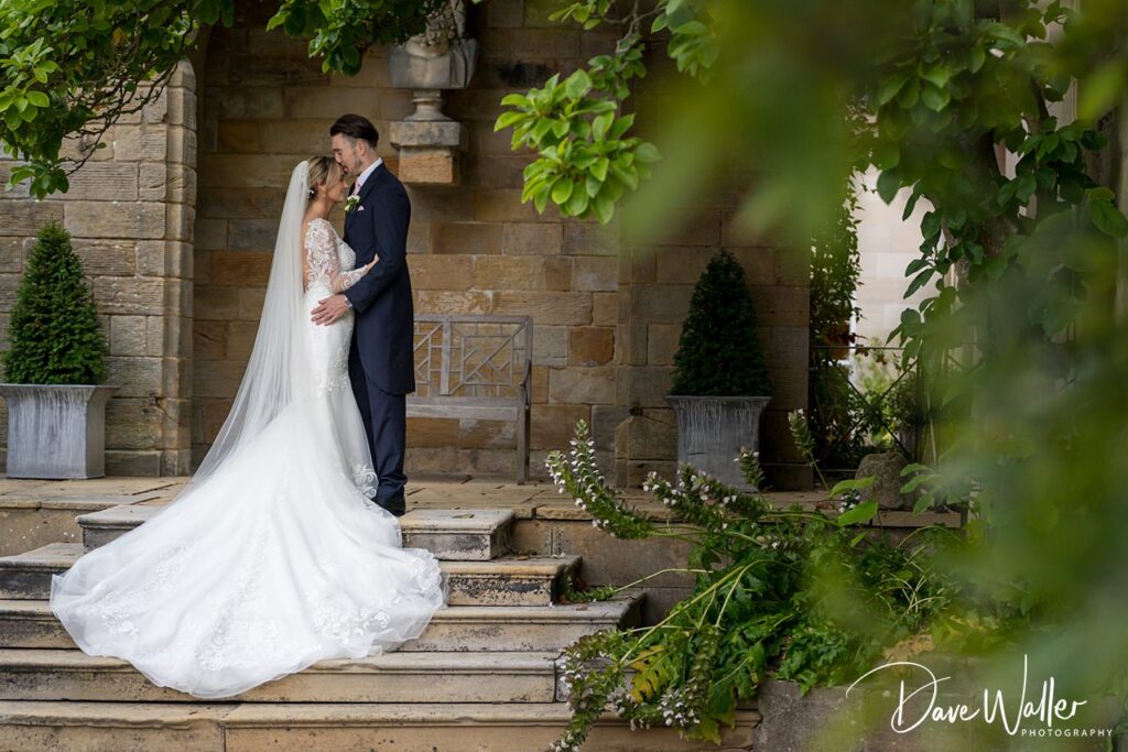 Bride and groom embracing at outdoor wedding venue.