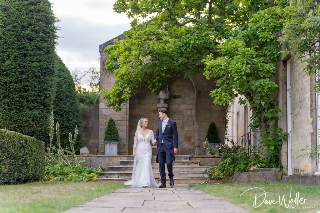 Bride and groom walking in garden