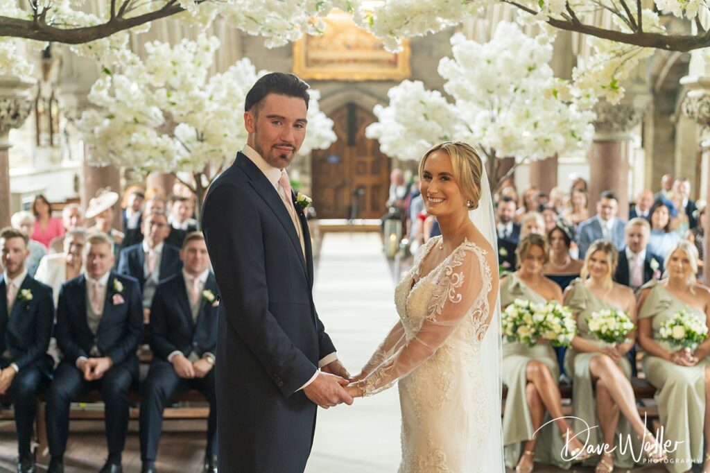 Bride and groom holding hands at wedding ceremony.