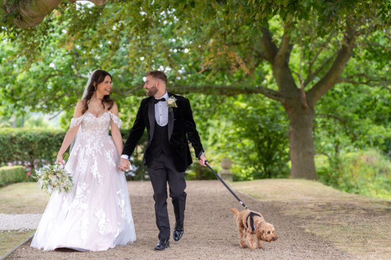 Lauren and Daniel walking Freddie the dog under the trees at Gisborough Hall