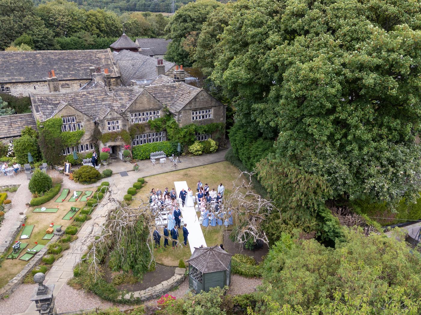 Aerial view of Holdsworth House near Halifax with guests gathered for the garden ceremony