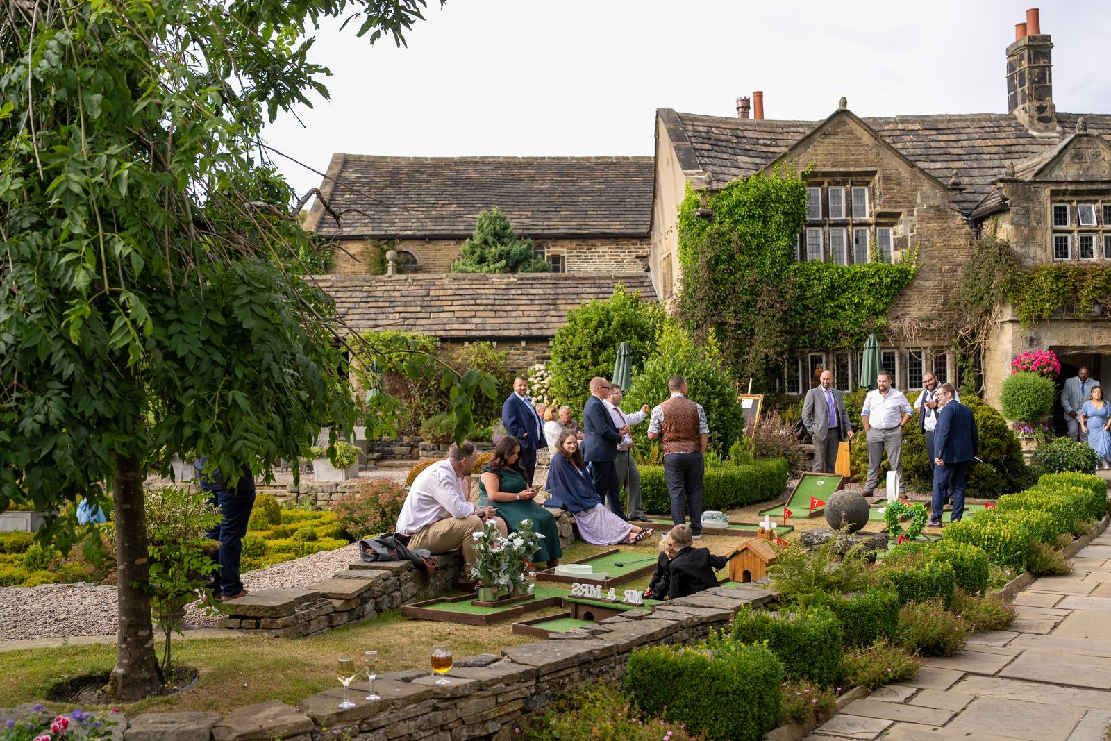 Guests enjoying the drinks reception in the terraced gardens in front of Holdsworth House
