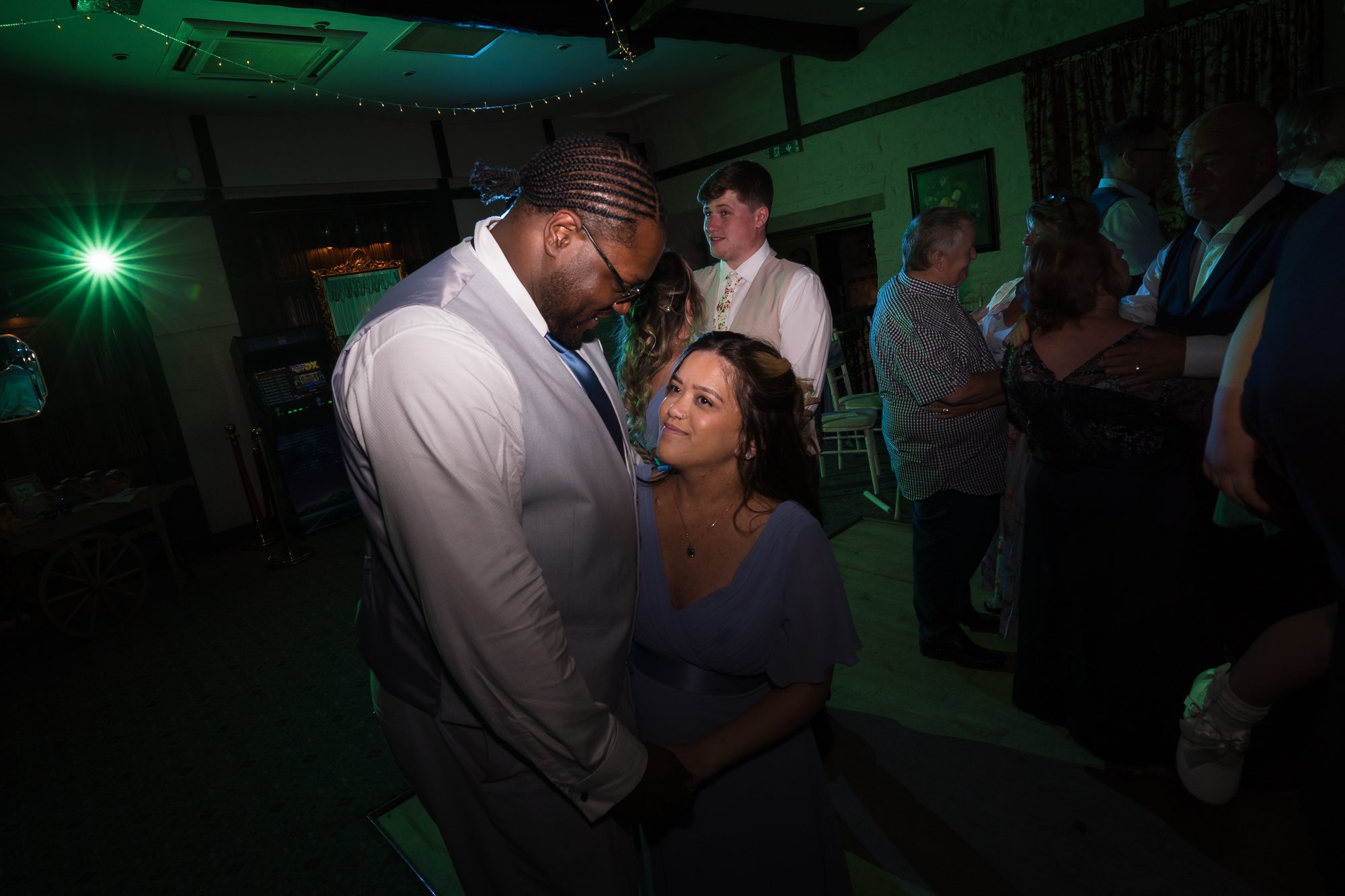 Guests on the dance floor under coloured lights at the evening reception