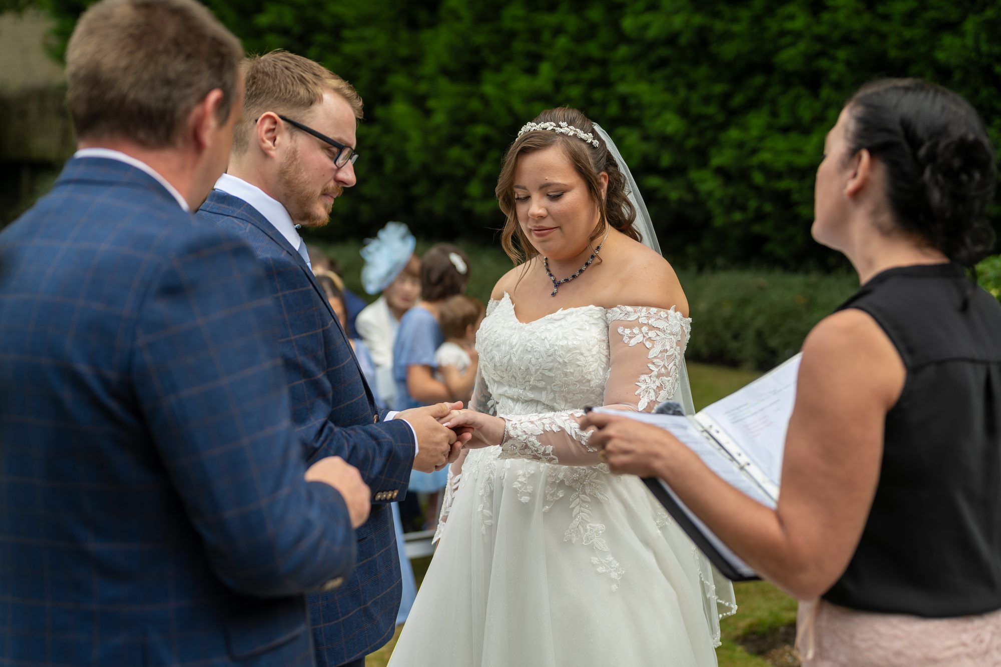 Scott placing the ring on Shannon's finger during their garden ceremony