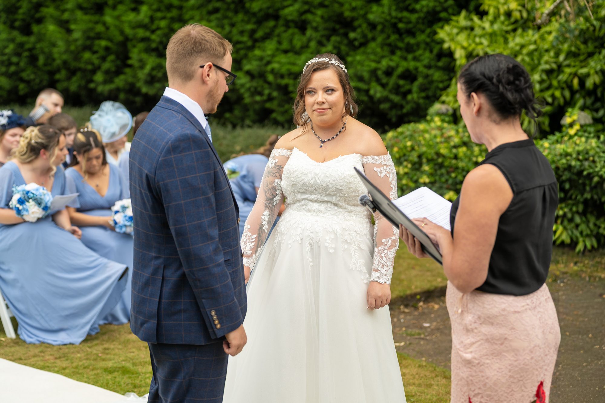 Shannon and Scott saying their vows at an outdoor ceremony at Holdsworth House