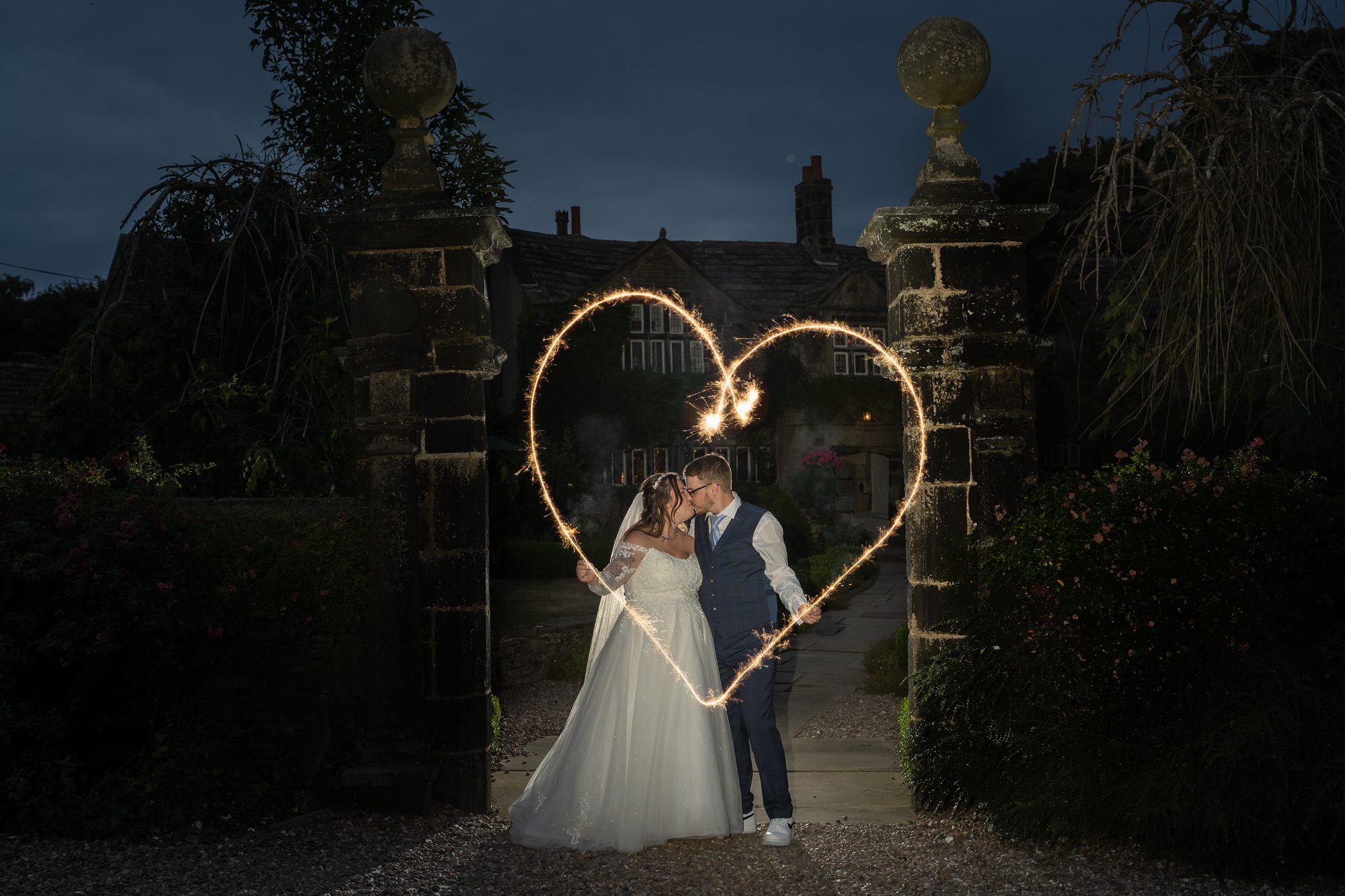 A light-painted heart around Shannon and Scott at the garden gates after dark