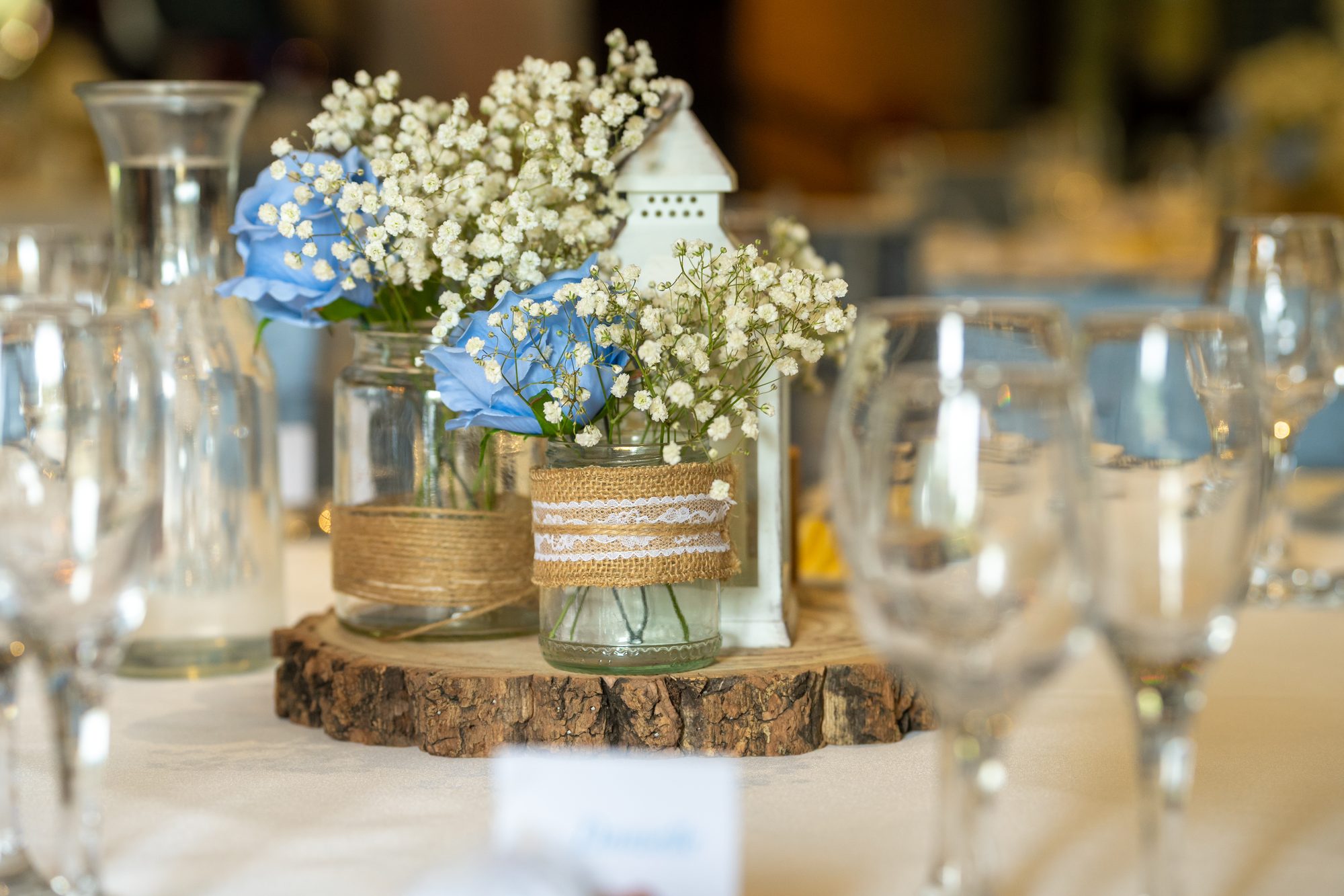 Blue hydrangeas and gypsophila on a log slice, one of the table centrepieces