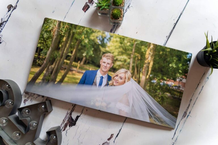 Wedding album open at a spread of a couple among trees