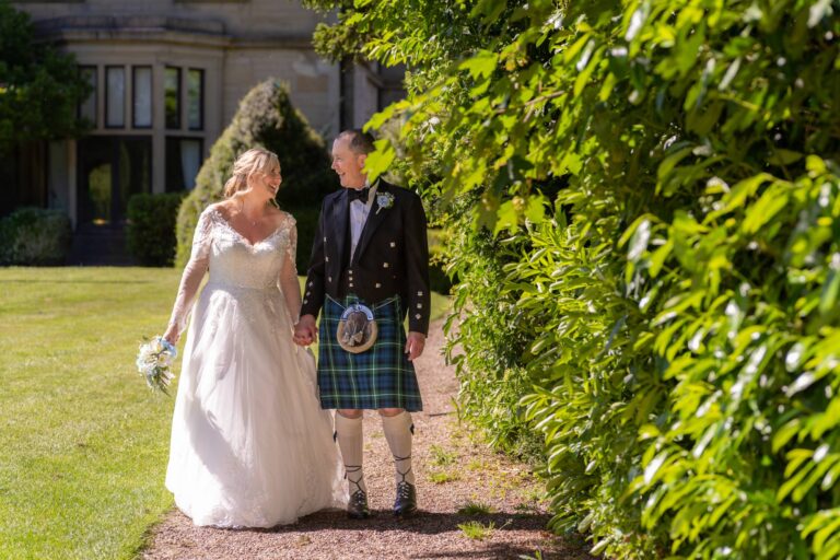 Tamsin and Alasdair walking hand in hand along a garden path at Bagden Hall